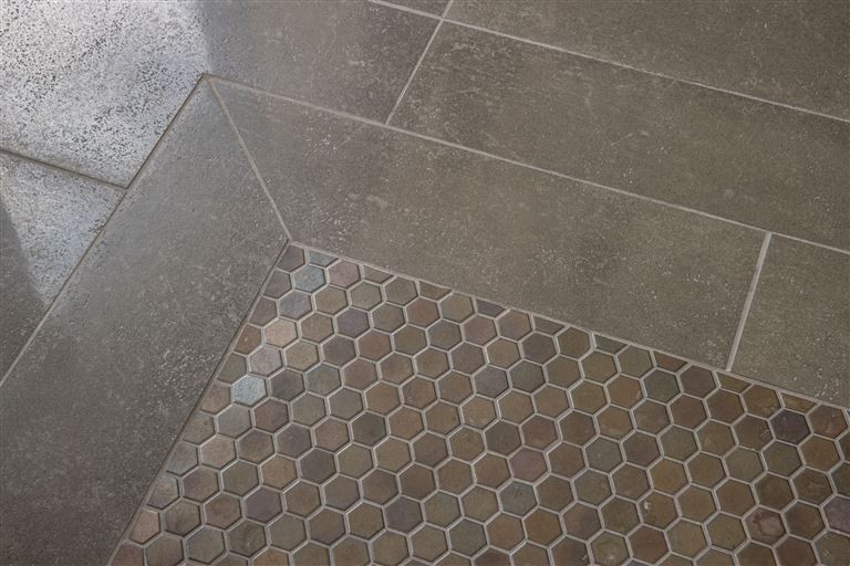 Closeup of gray mosaic tile design with intricate pattern.