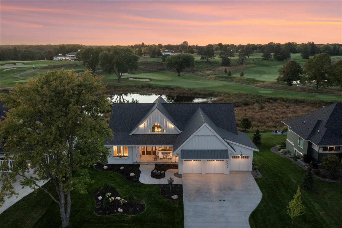 Aerial view of a lakeside mansion with a garden and lawn.