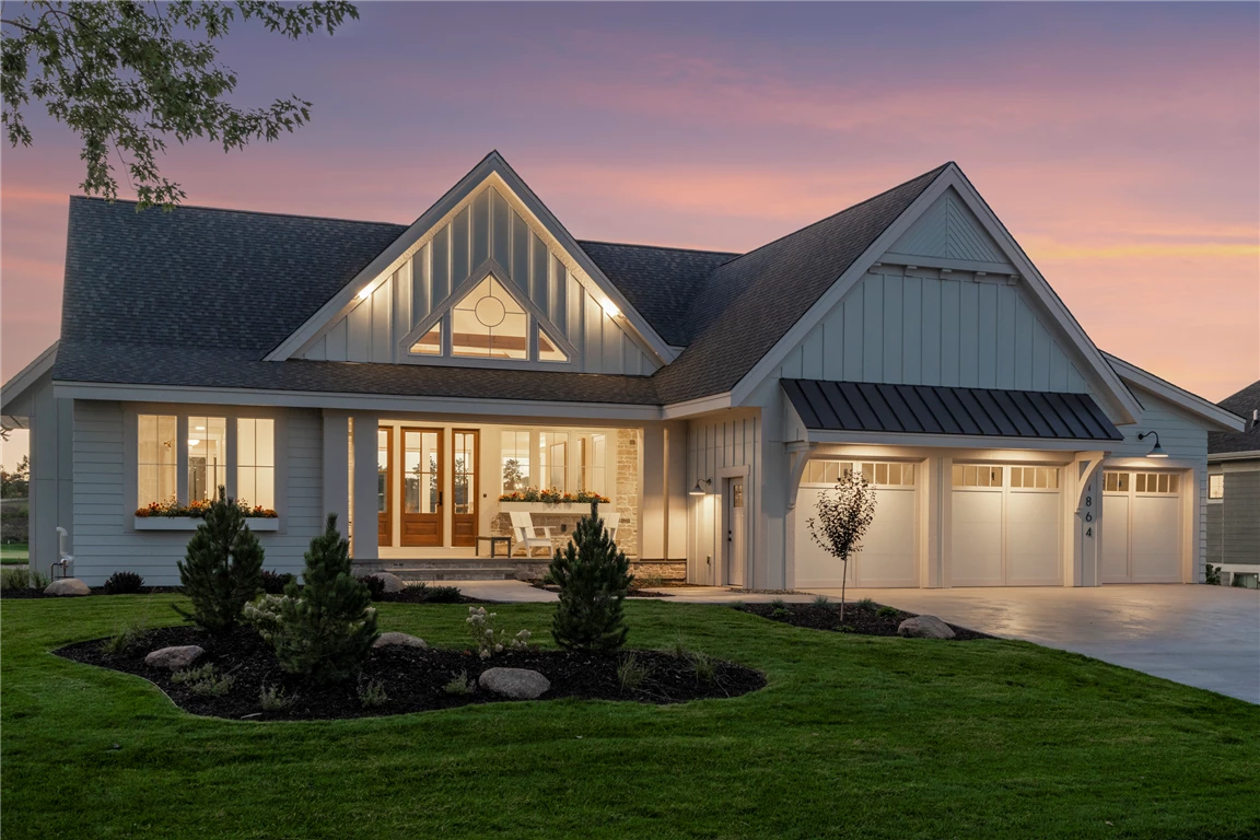 Front view of a luxury suburban mansion with a spacious driveway and well-kept lawn.