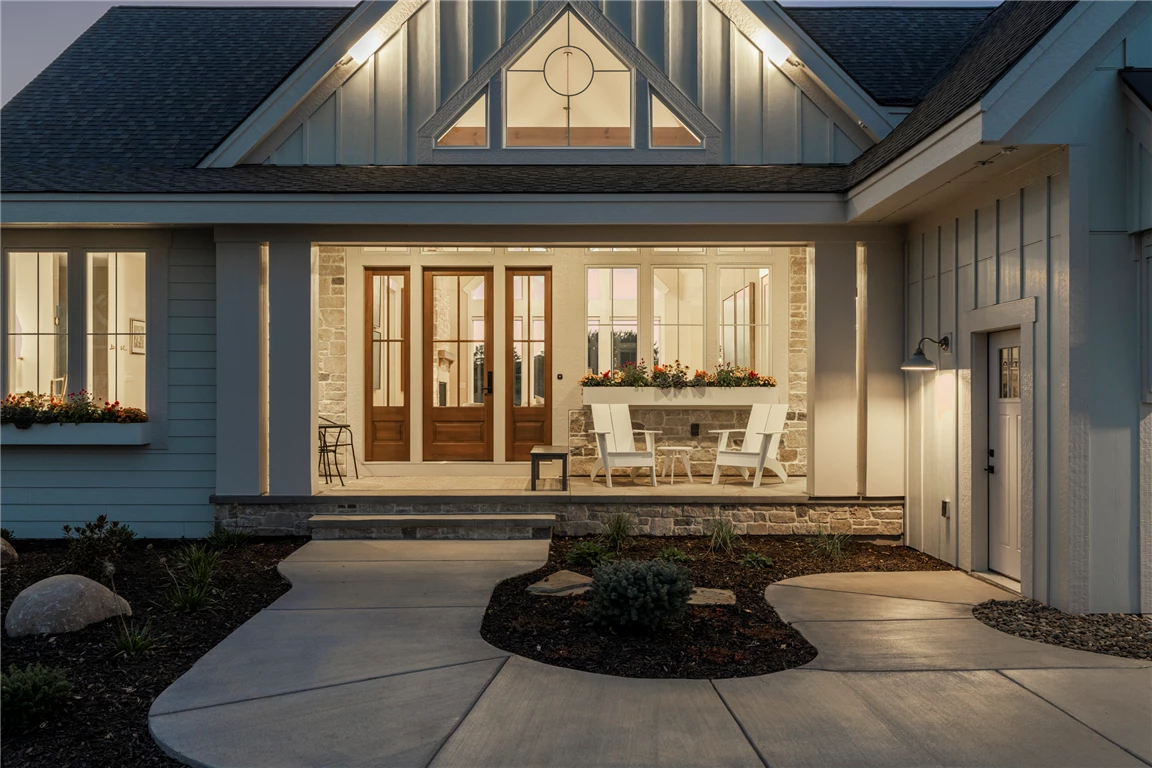 Front exterior of a luxury suburban home with a porch and elegant doorway.