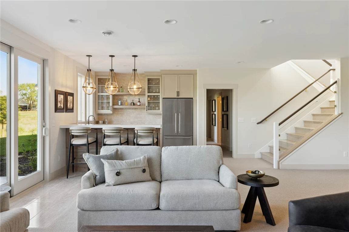 Contemporary family room with sofa, chairs, coffee table, and view of stairway and kitchen.