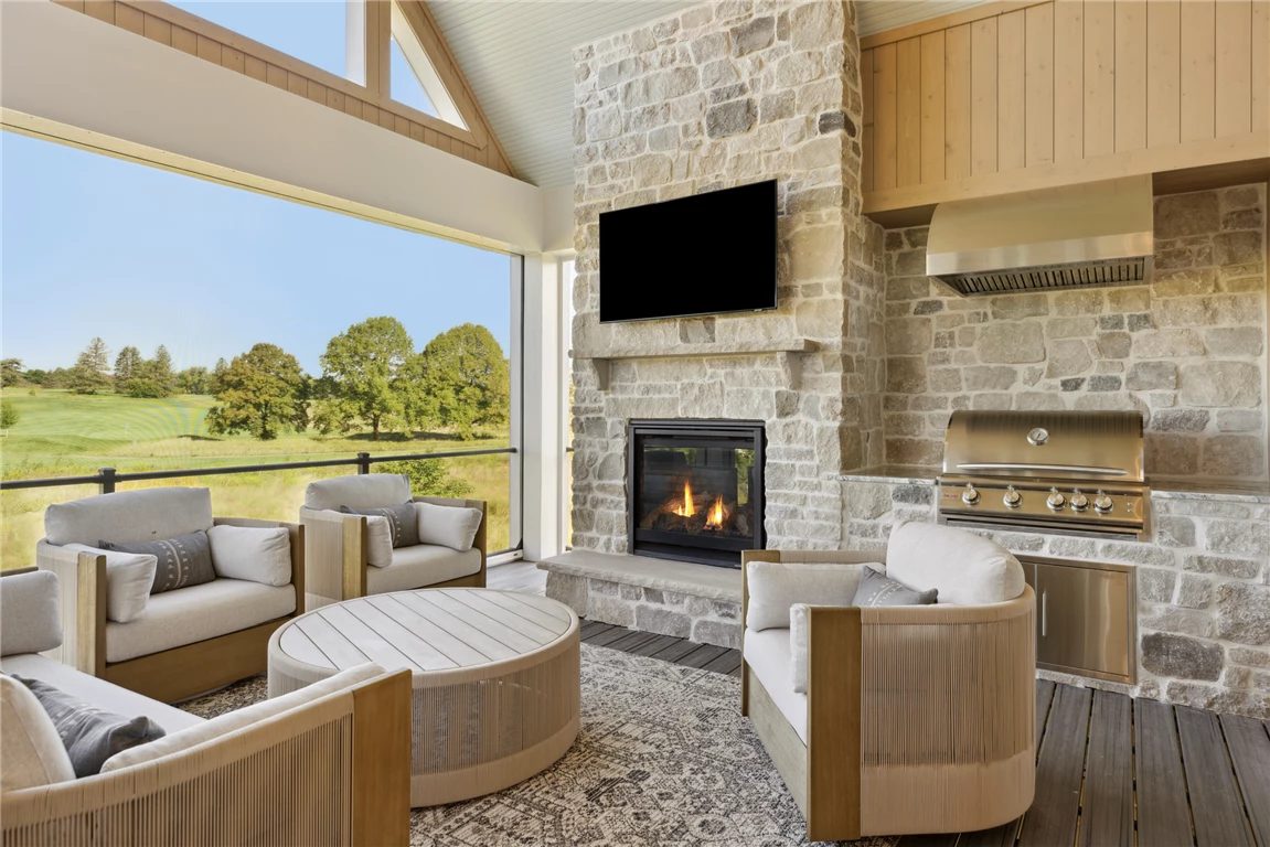 Contemporary four-season porch with minimalist furniture and a fireplace.