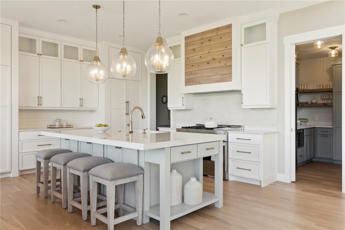 Contemporary family room with modern kitchen design, featuring a dining table, chairs, refrigerator, and large windows.