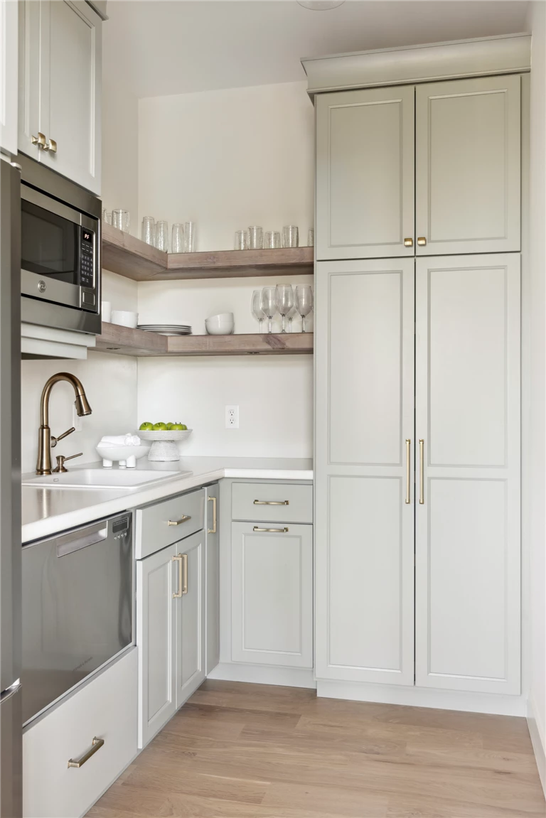 Modern kitchen pantry with cabinets, refrigerator, and oven.