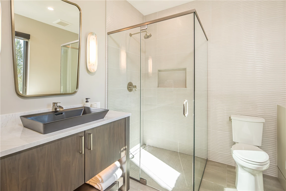 Luxurious contemporary minimalist bathroom with a bathtub, shower, and large mirror.