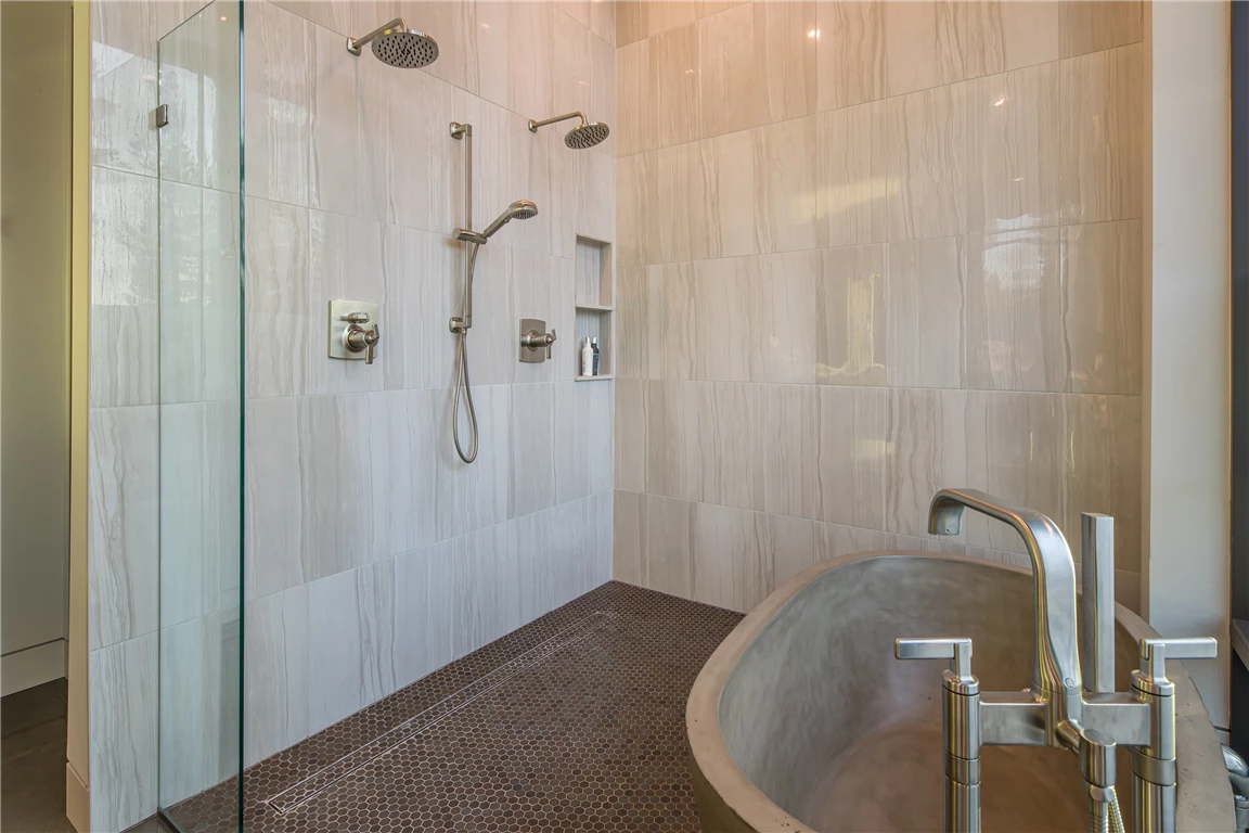 Contemporary bathroom with mirror, shower, and bathtub.