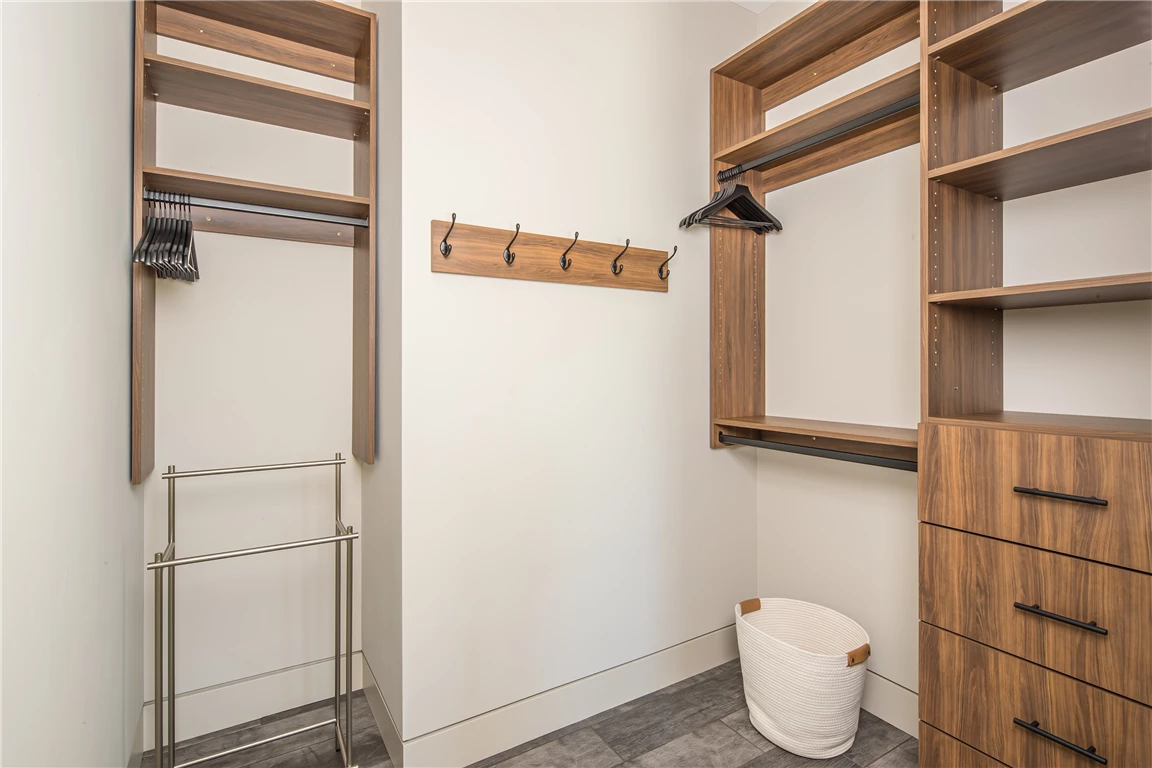 Contemporary built-in closet with wooden shelves and drawers in a minimalist design.