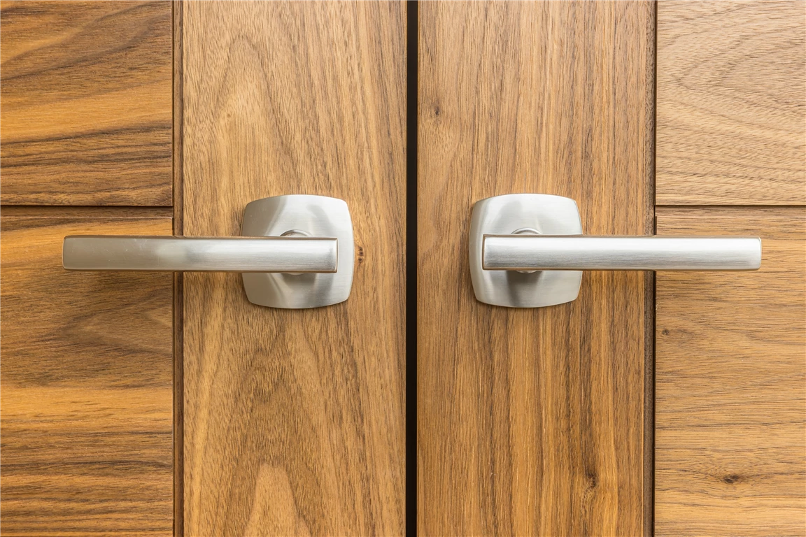 Closeup of a wooden door with a brass doorknob and lock.