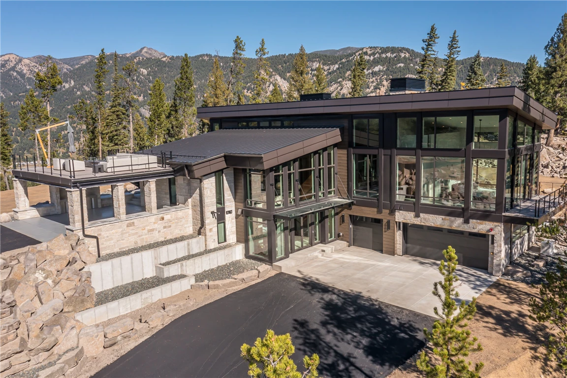 Bungalow exterior with mountains and trees in the background.