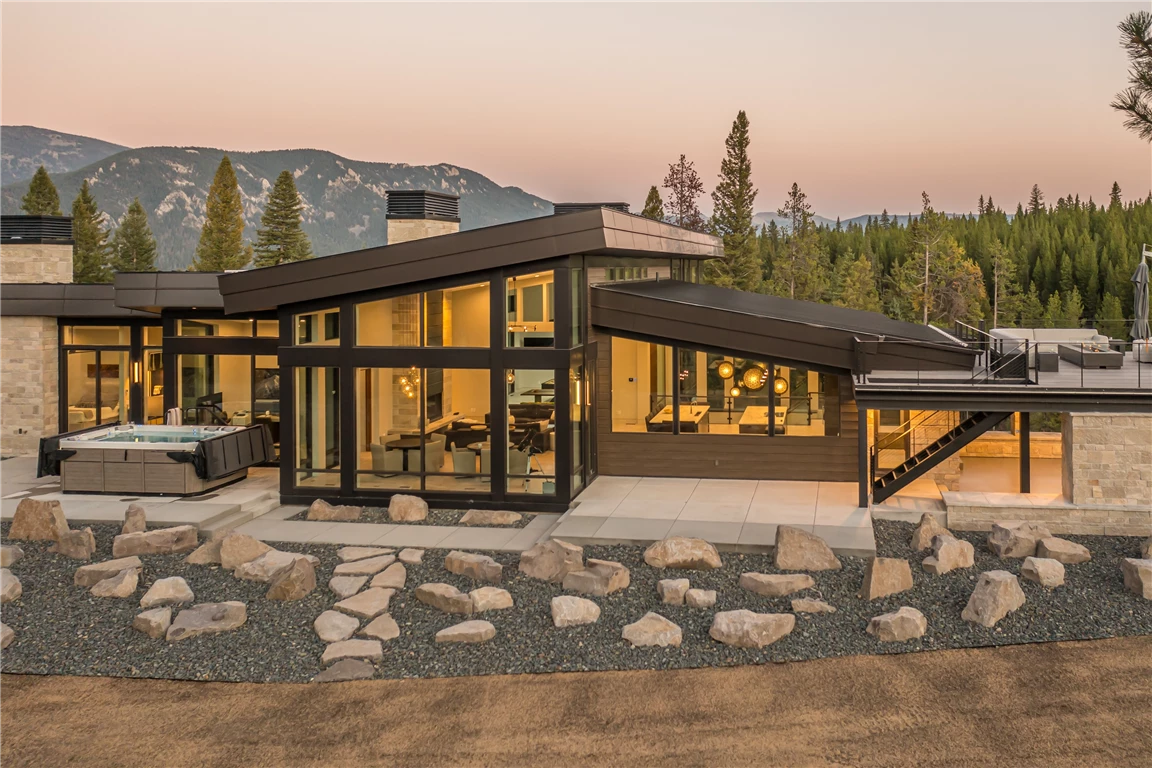 Wooden house exterior at sunset with trees and a serene landscape.