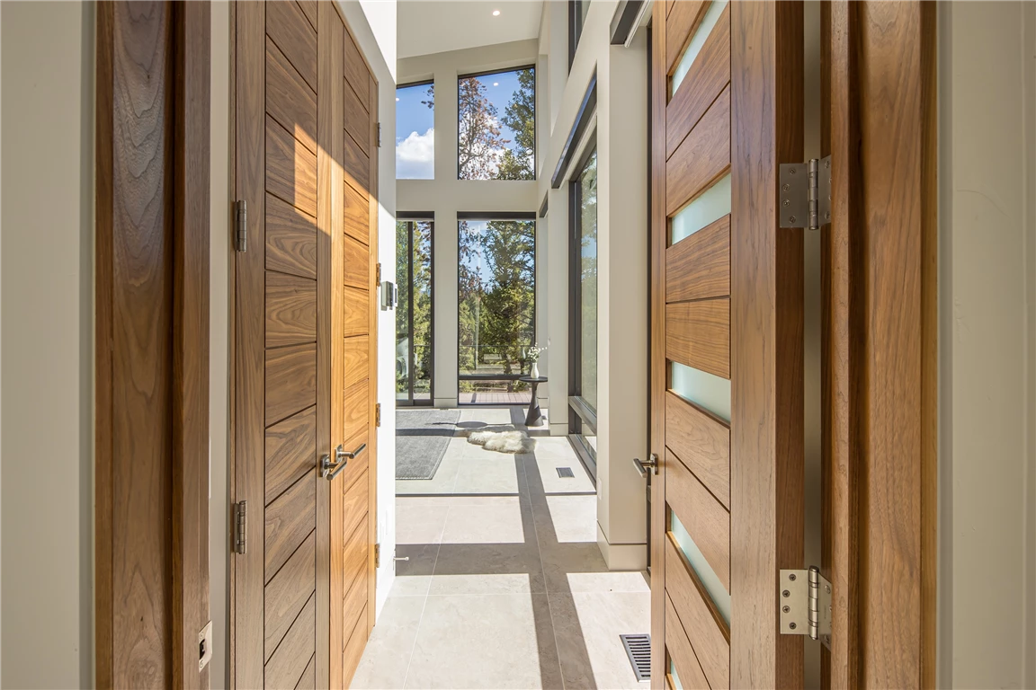 Luxurious contemporary hallway with wooden door and wardrobe.