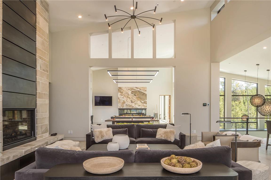 Contemporary luxury living room with sofa, coffee table, chair, and fireplace.